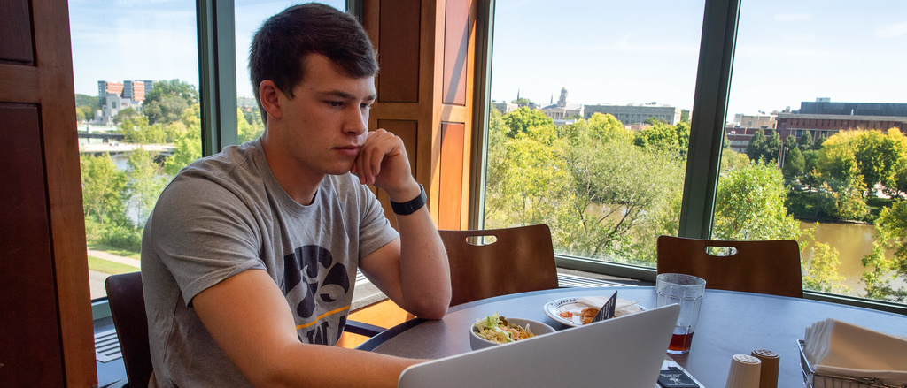 Man sits at dining table in Hillcrest residence hall.