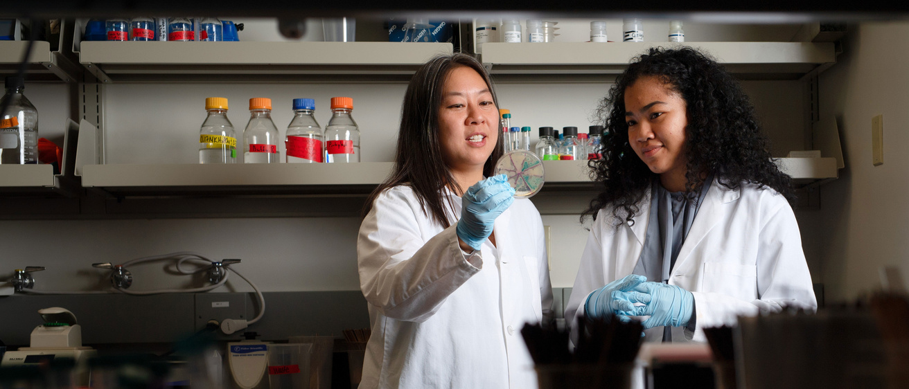 Teacher and student in lab coats