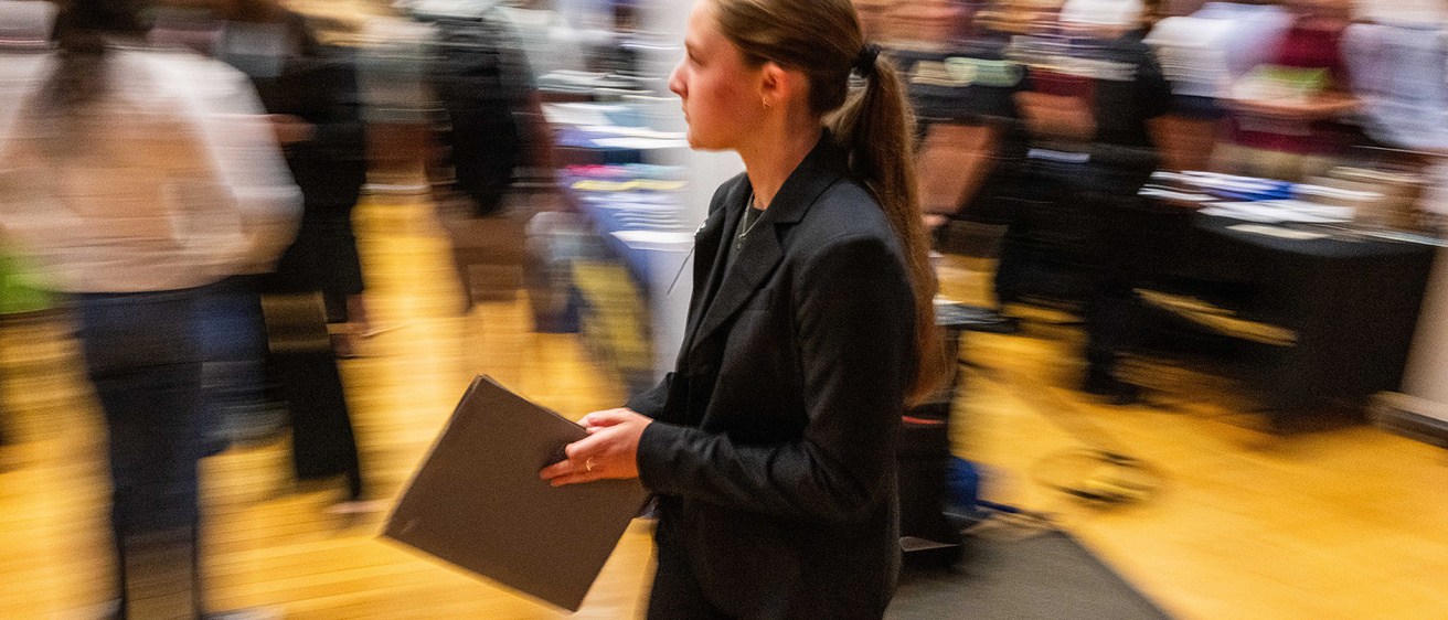 a person at a career fair holding her credentials