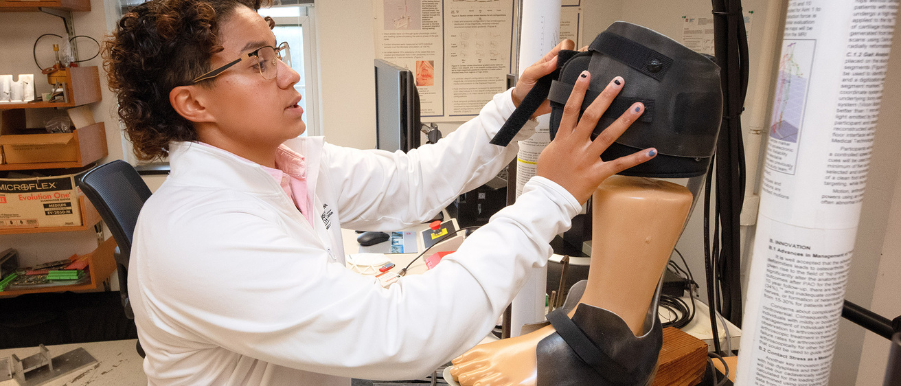 a biomedical engineering student working with a prosthetic in a lab