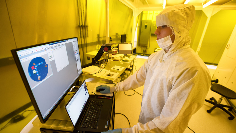 A student works on a computer in a nanofabrication lab.