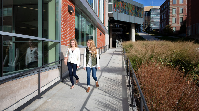 Two students walking in front of Catlett residence hall.