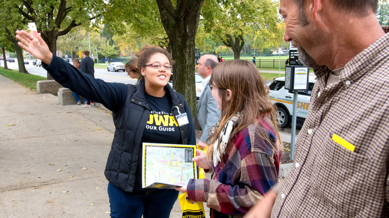 Tour guide giving directions to campus visitors.