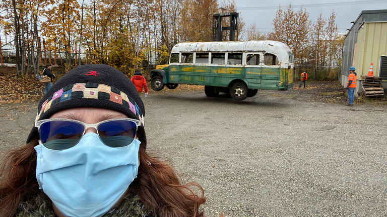 UIowa graduate Angela Linn in front of Christopher McCandless' Alaska bus