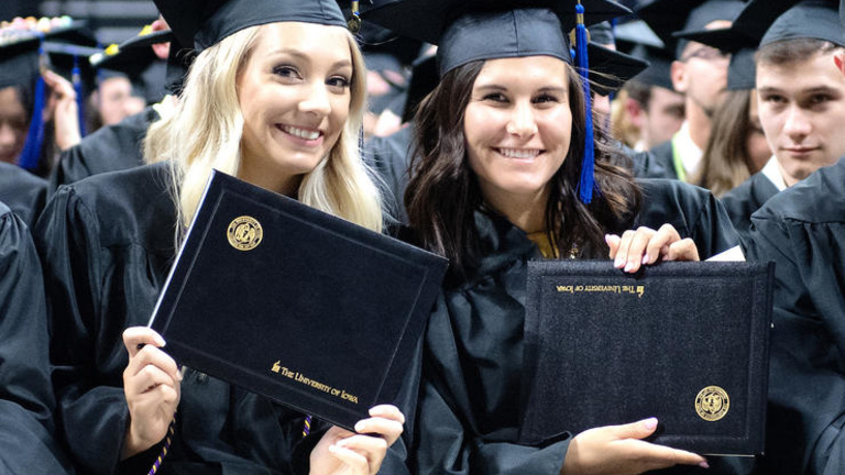 University of Iowa students holding degrees