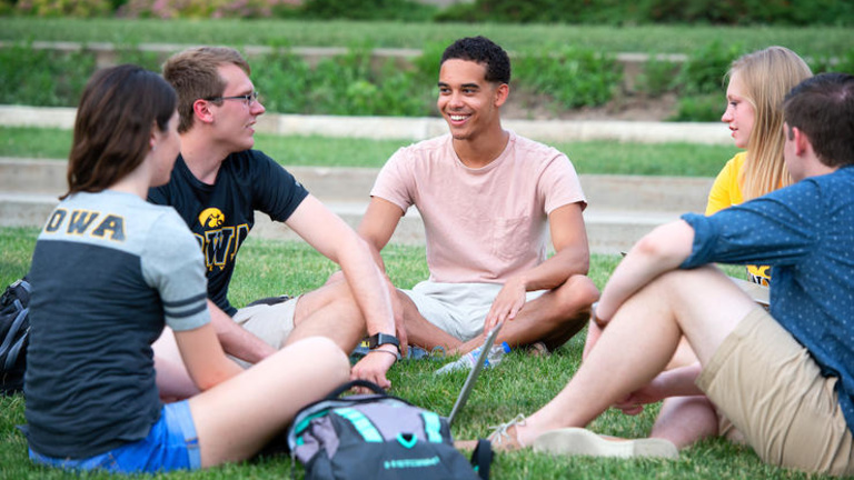 Iowa students sitting on pentacrest