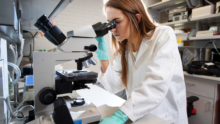 Megan Crotts looking into microscope